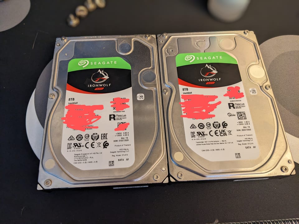 A pair of Seagate Ironwolf 8TB hard drives, with scribbles over the serial numbers and barcodes